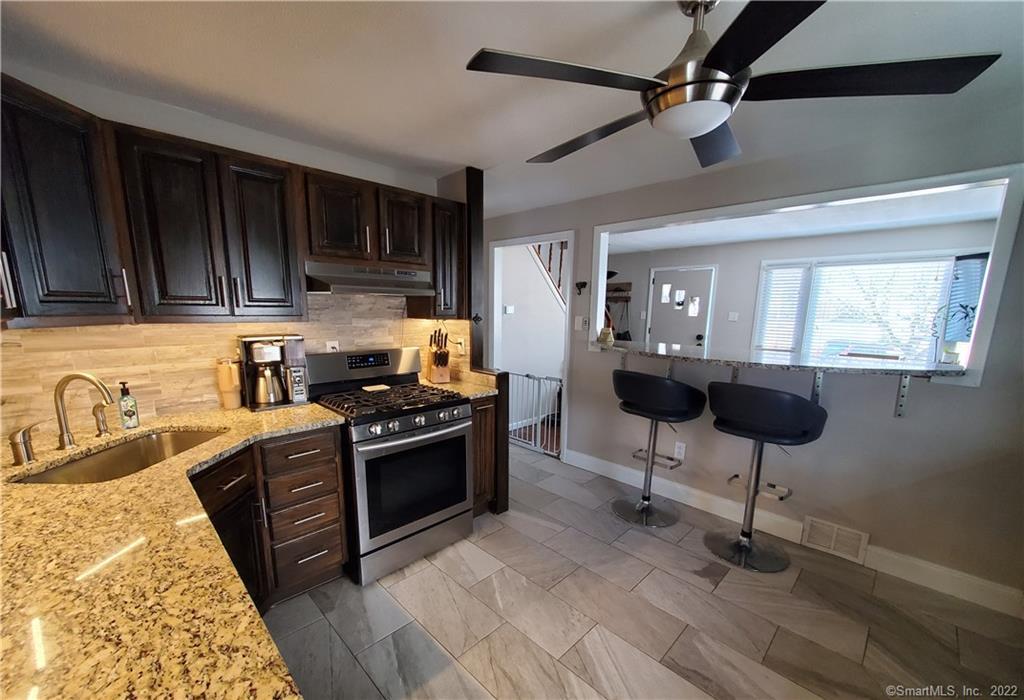 a kitchen with granite countertop a sink cabinets and stainless steel appliances