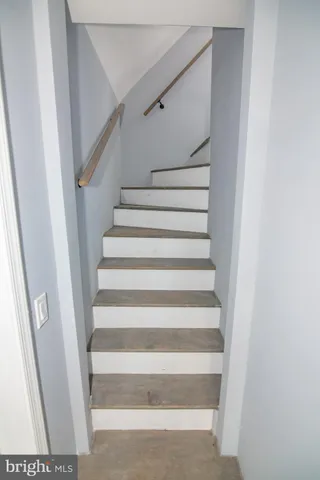 a view of staircase with white walls and a window