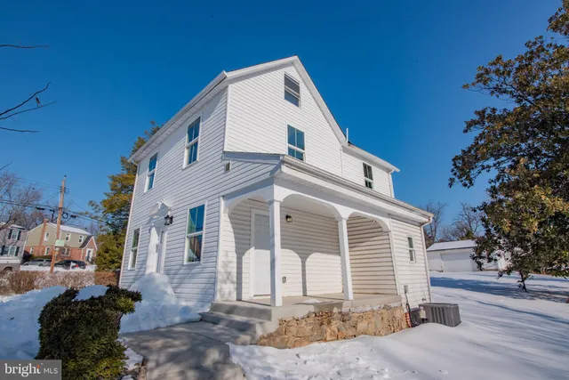 a view of a white house with a yard