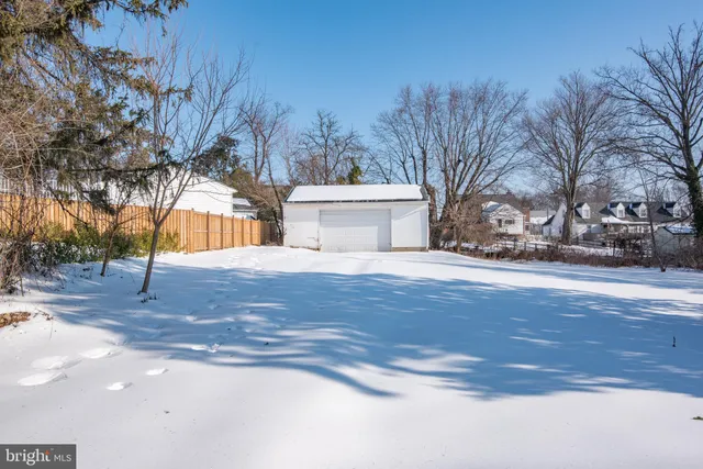 a front view of a house with a snow on the road