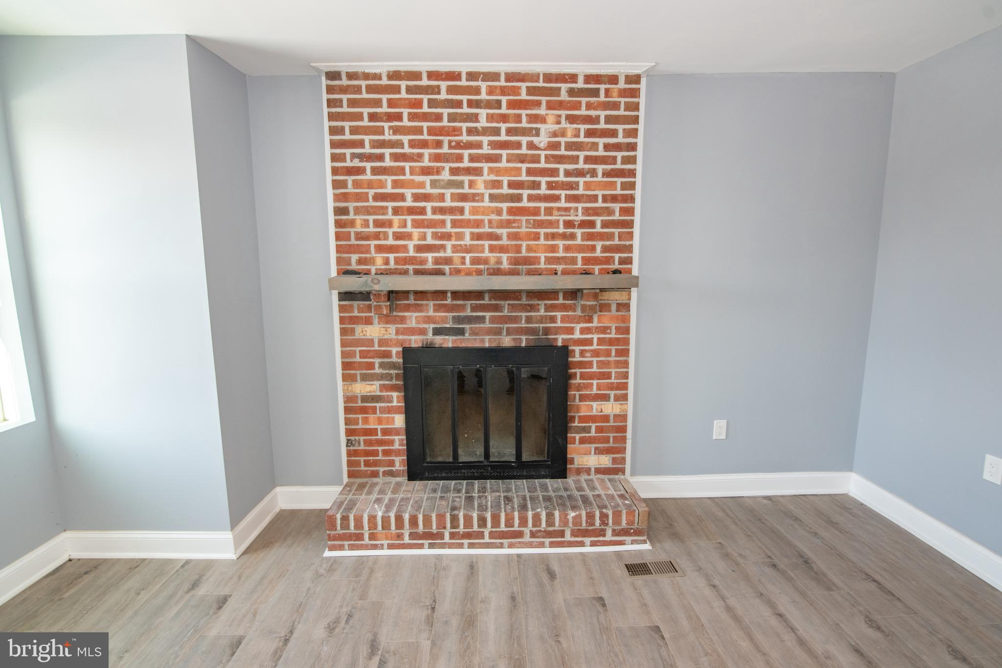2900 Scherer Avenue Baltimore, MD 21234 - Photo 4 of 37 a view of an empty room with wooden floor and a fireplace