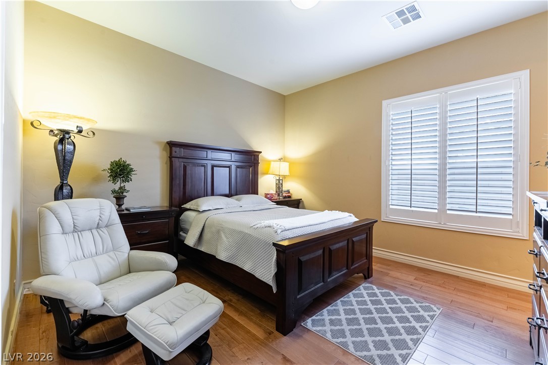3661 Riley Ann Avenue Las Vegas, NV 89139 - Photo 23 of 42 Rich hardwood floors complement this cozy bedroom with natural illumination and warm tones.