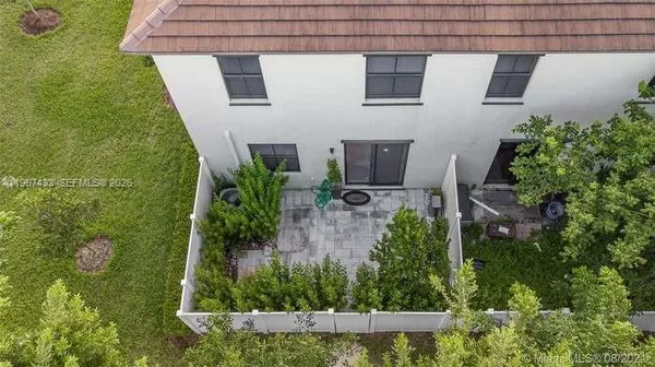 a aerial view of a house with a yard and potted plants