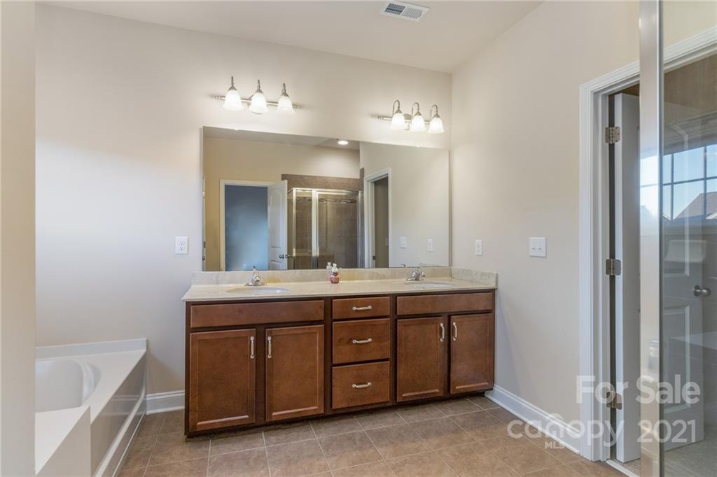 2263 Eversham Drive Northwest Concord, NC 28027 - Photo 6 of 21 a spacious bathroom with a granite countertop double vanity sink a mirror and a bathtub