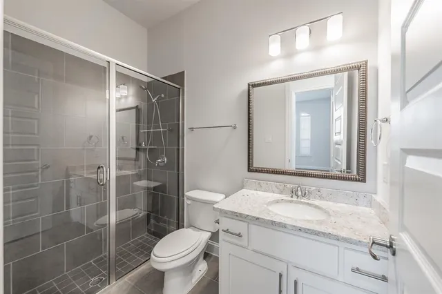 a bathroom with a granite countertop sink toilet and shower
