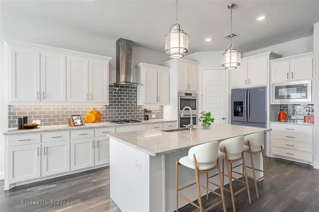 a kitchen with kitchen island granite countertop a sink cabinets and stainless steel appliances