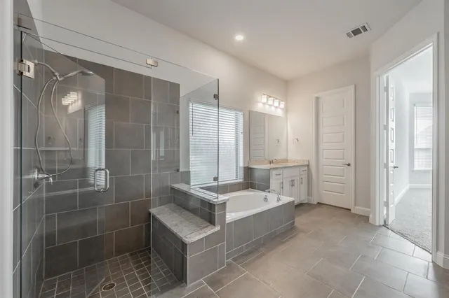 a spacious bathroom with a double vanity sink a large mirror and shower