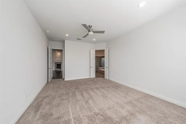 an empty room with closet and a ceiling fan