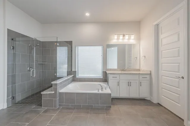 a spacious bathroom with a tub shower and sink