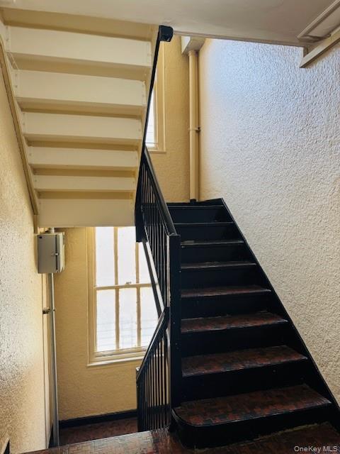 48-20 44th Street, Unit 4C Queens, NY 11377 - Photo 4 of 12 Stairs with a textured wall and baseboards