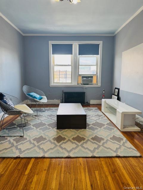 48-20 44th Street, Unit 4C Queens, NY 11377 - Photo 7 of 12 Living area featuring wood finished floors, radiator, and ornamental molding