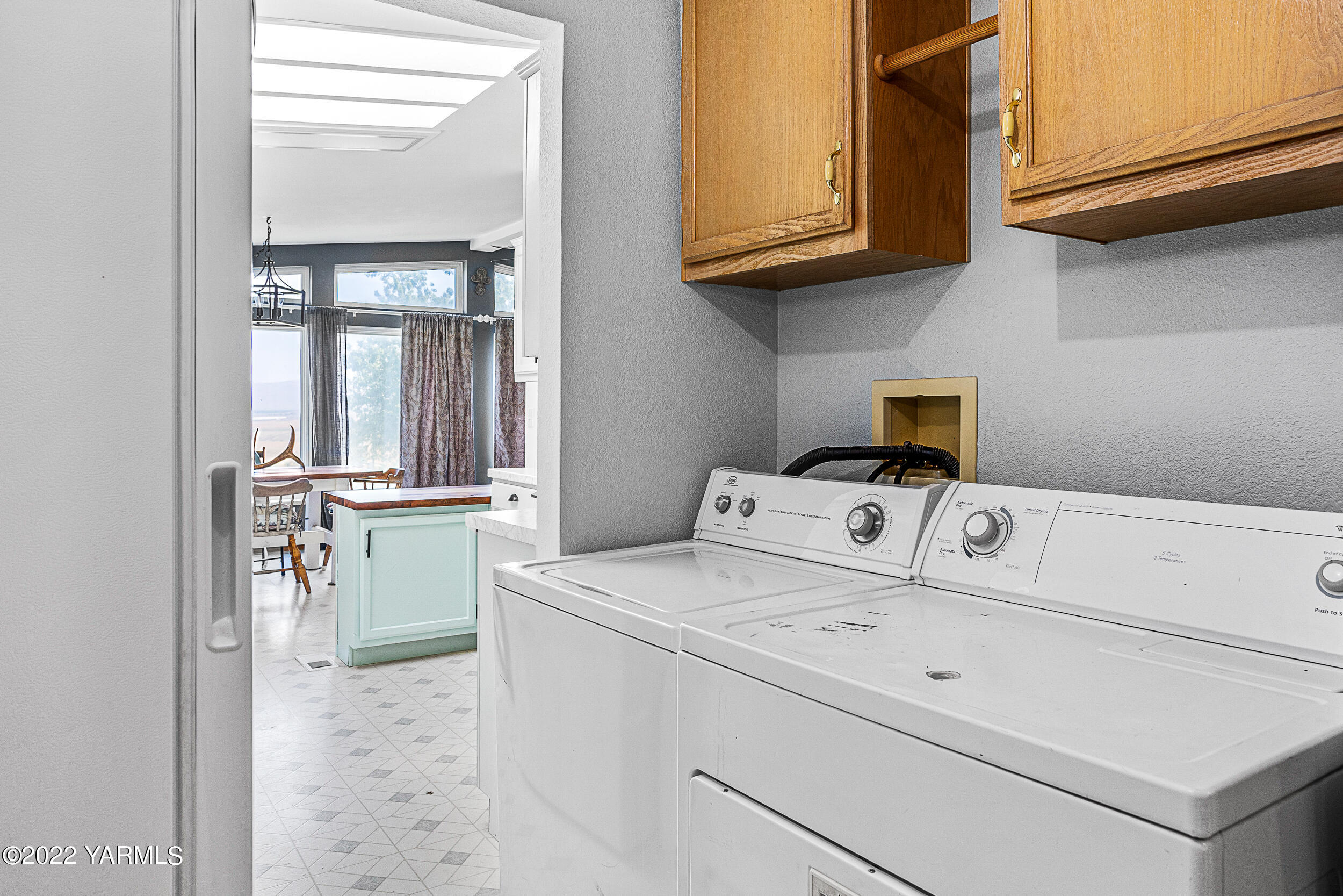 341 Winchester Road Yakima, WA 98908 - Photo 24 of 38 a view of washer and dryer with kitchen in the background