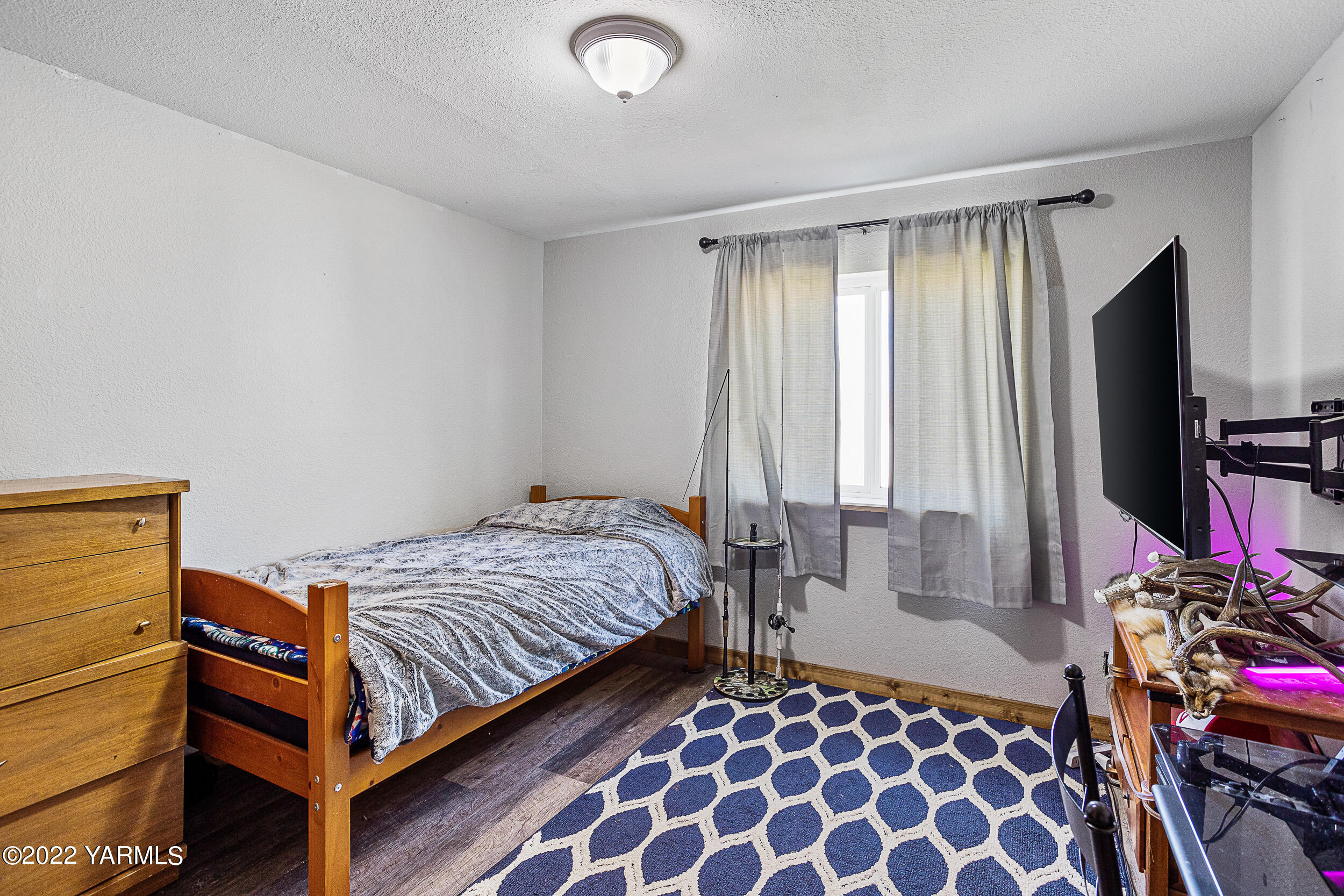 341 Winchester Road Yakima, WA 98908 - Photo 29 of 38 a bedroom with a bed and a flat tv screen on a dresser