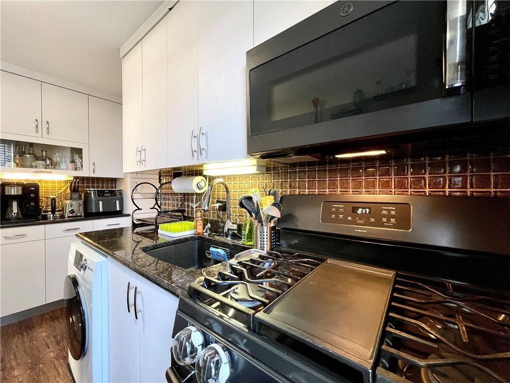 3235 Emmons Avenue, Unit 516 Brooklyn, NY 11235 - Photo 2 of 3 a kitchen with a stove and a microwave