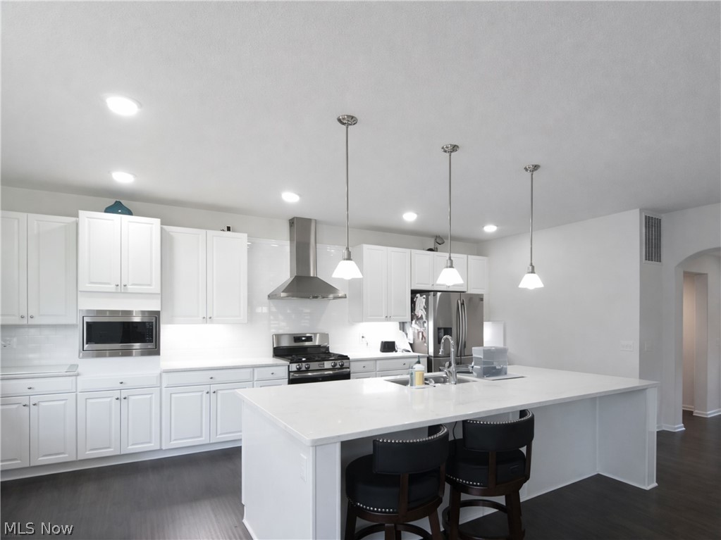 4509 Millbrook Way Akron, OH 44321 - Photo 8 of 27 Contemporary kitchen featuring white cabinetry, a large center island with pendant lighting, stainless steel appliances, a tile backsplash, and recessed lighting