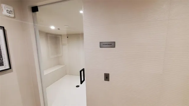 a view of a hallway to a livingroom with furniture and natural light