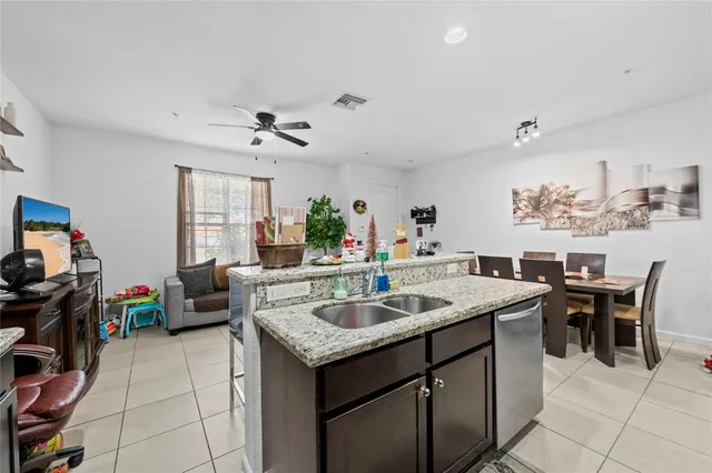 a dining hall with stainless steel appliances granite countertop a sink and a refrigerator
