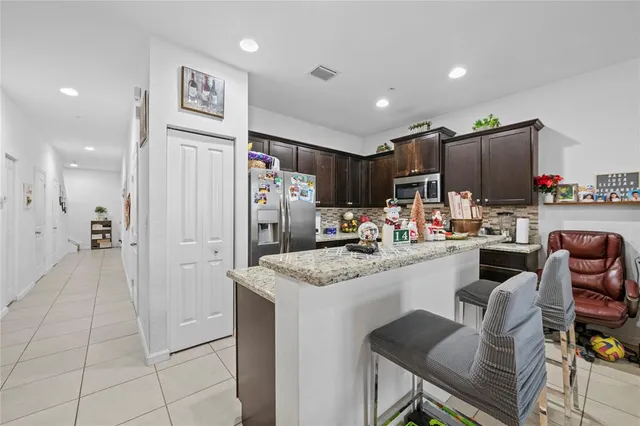 a kitchen with stainless steel appliances granite countertop a refrigerator and a sink