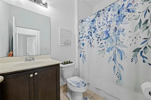a bathroom with a granite countertop sink a toilet and a mirror