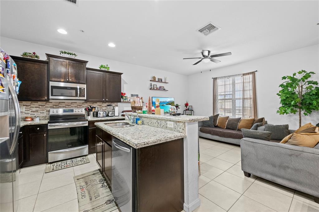 197 Southwest 6th Place, Unit 197 Pompano Beach, FL 33060 - Photo 7 of 25 a living room with stainless steel appliances kitchen island granite countertop a couch and a living room view