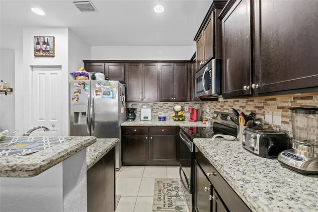 a kitchen with granite countertop a sink stainless steel appliances and counter space