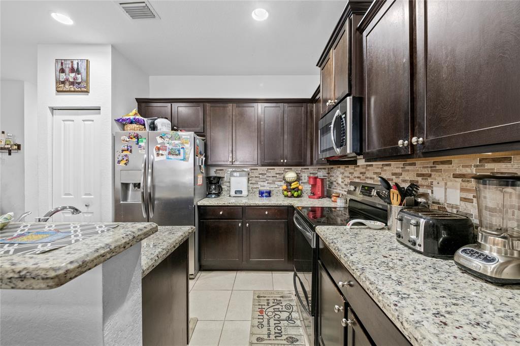 197 Southwest 6th Place, Unit 197 Pompano Beach, FL 33060 - Photo 8 of 25 a kitchen with granite countertop a sink stainless steel appliances and counter space