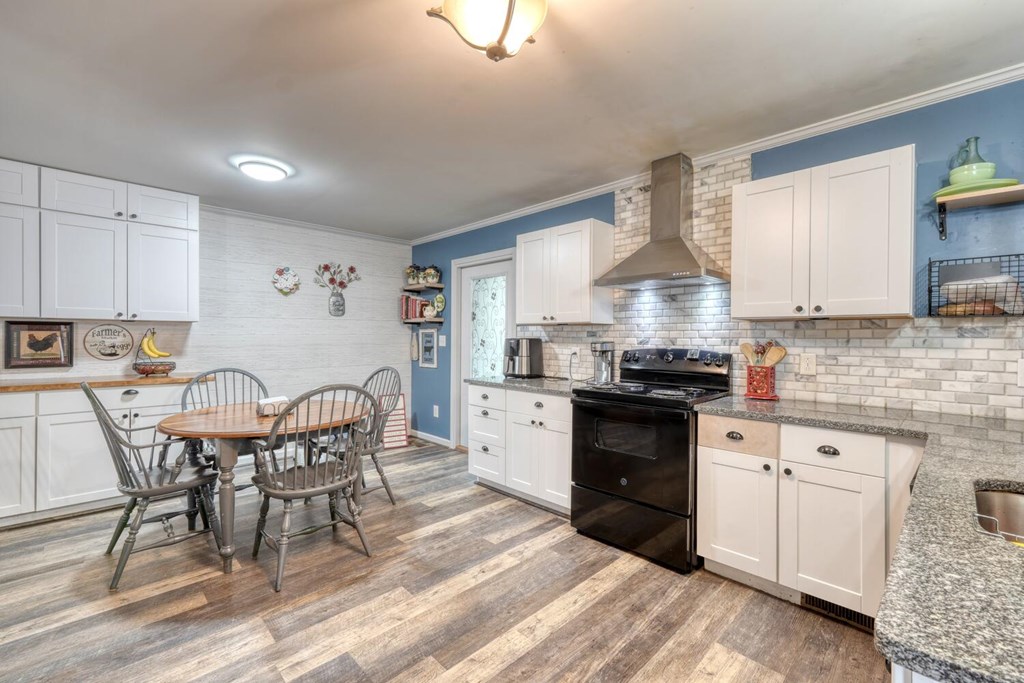 109 Hefner Road Blairsville, GA 30512 - Photo 9 of 48 a kitchen with stainless steel appliances granite countertop a stove a sink dishwasher a dining table and chairs with wooden floor