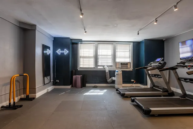 a room with gym equipment and large mirror