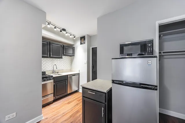 a kitchen with a refrigerator sink and stove top oven