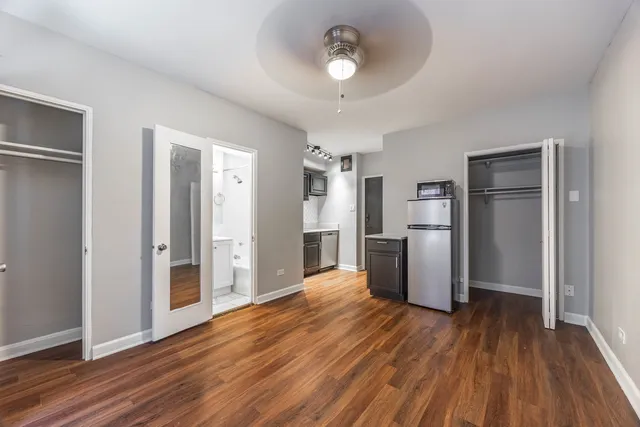 a view of a kitchen with refrigerator and wooden floor