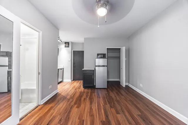 a view of empty room with wooden floor
