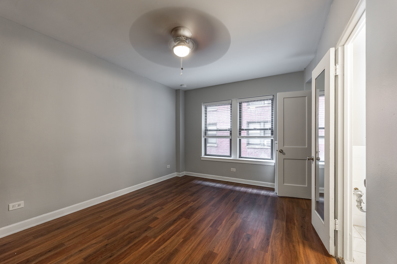 1140 North LaSalle Drive, Unit 203 Chicago, IL 60610 - Photo 7 of 25 an empty room with wooden floor and windows
