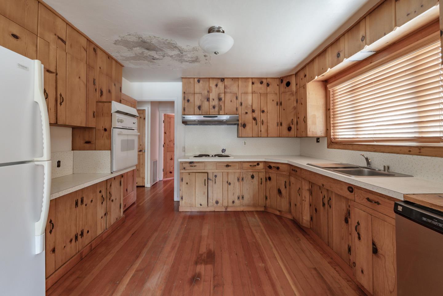 137 Whiting Road Watsonville, CA 95076 - Photo 12 of 52 a kitchen with wooden floors and white cabinets