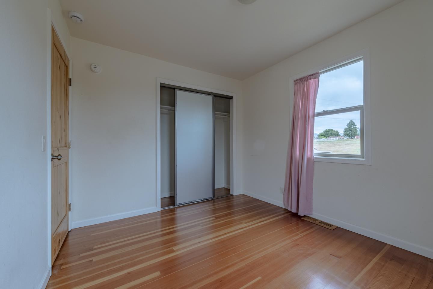 137 Whiting Road Watsonville, CA 95076 - Photo 18 of 52 an empty room with wooden floor and windows