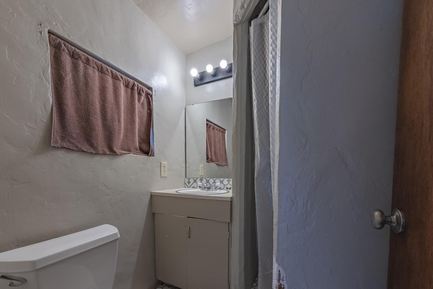 137 Whiting Road Watsonville, CA 95076 - Photo 32 of 52 a bathroom with a toilet sink vanity and mirror