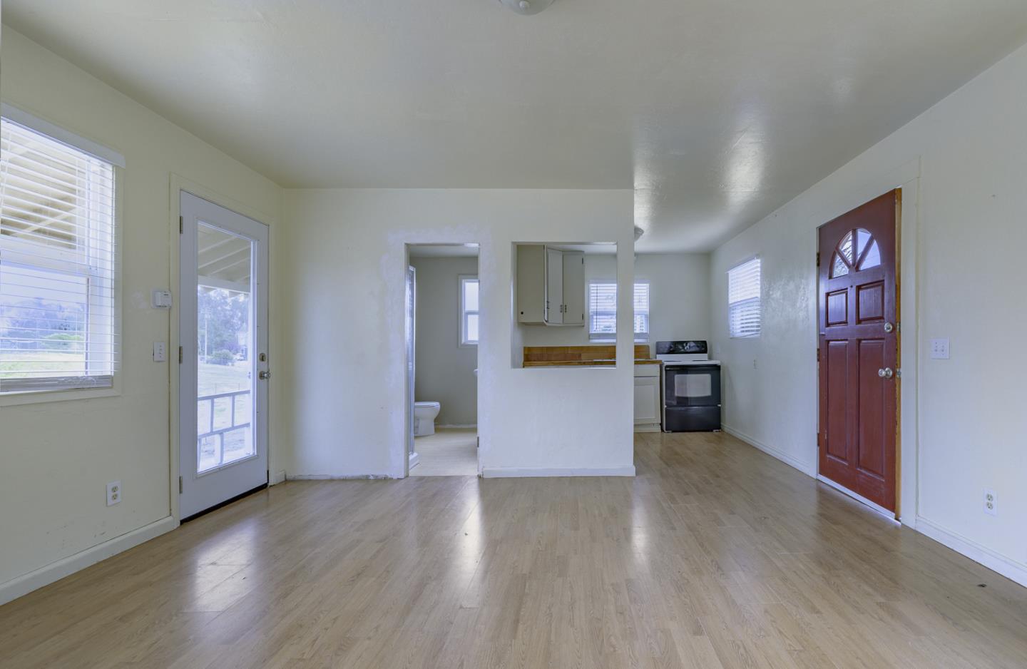 137 Whiting Road Watsonville, CA 95076 - Photo 34 of 52 an empty room with wooden floor and kitchen view