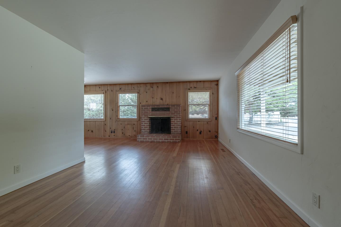 137 Whiting Road Watsonville, CA 95076 - Photo 6 of 52 an empty room with wooden floor fireplace and windows