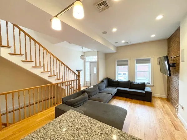 a living room with wooden floor and a couch