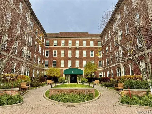 front view of a brick building with a yard