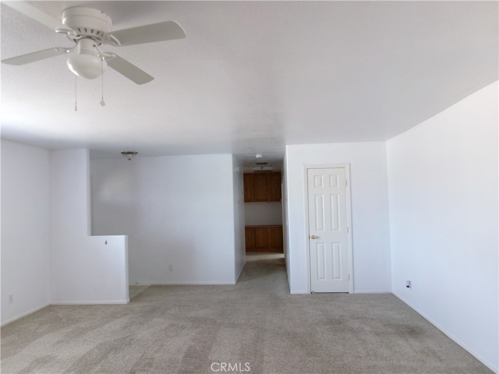 14936 Central Road Apple Valley, CA 92307 - Photo 15 of 33 an empty room with chandelier fan and closet area