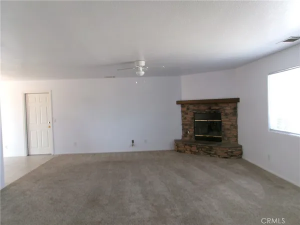 an empty room with a fireplace and window
