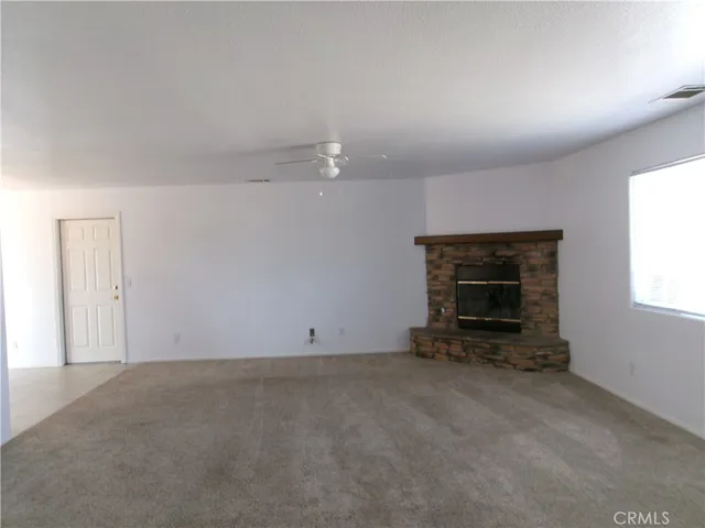 an empty room with a fireplace and window
