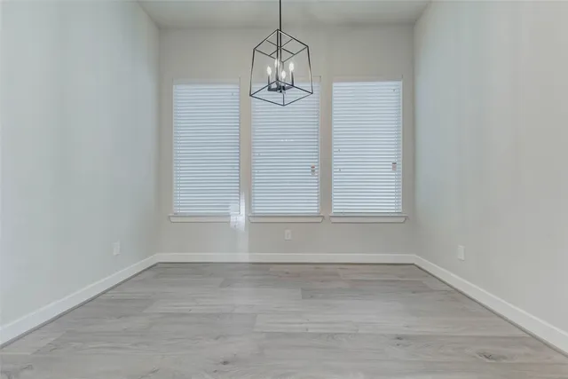 a view of empty room with window and wooden floor