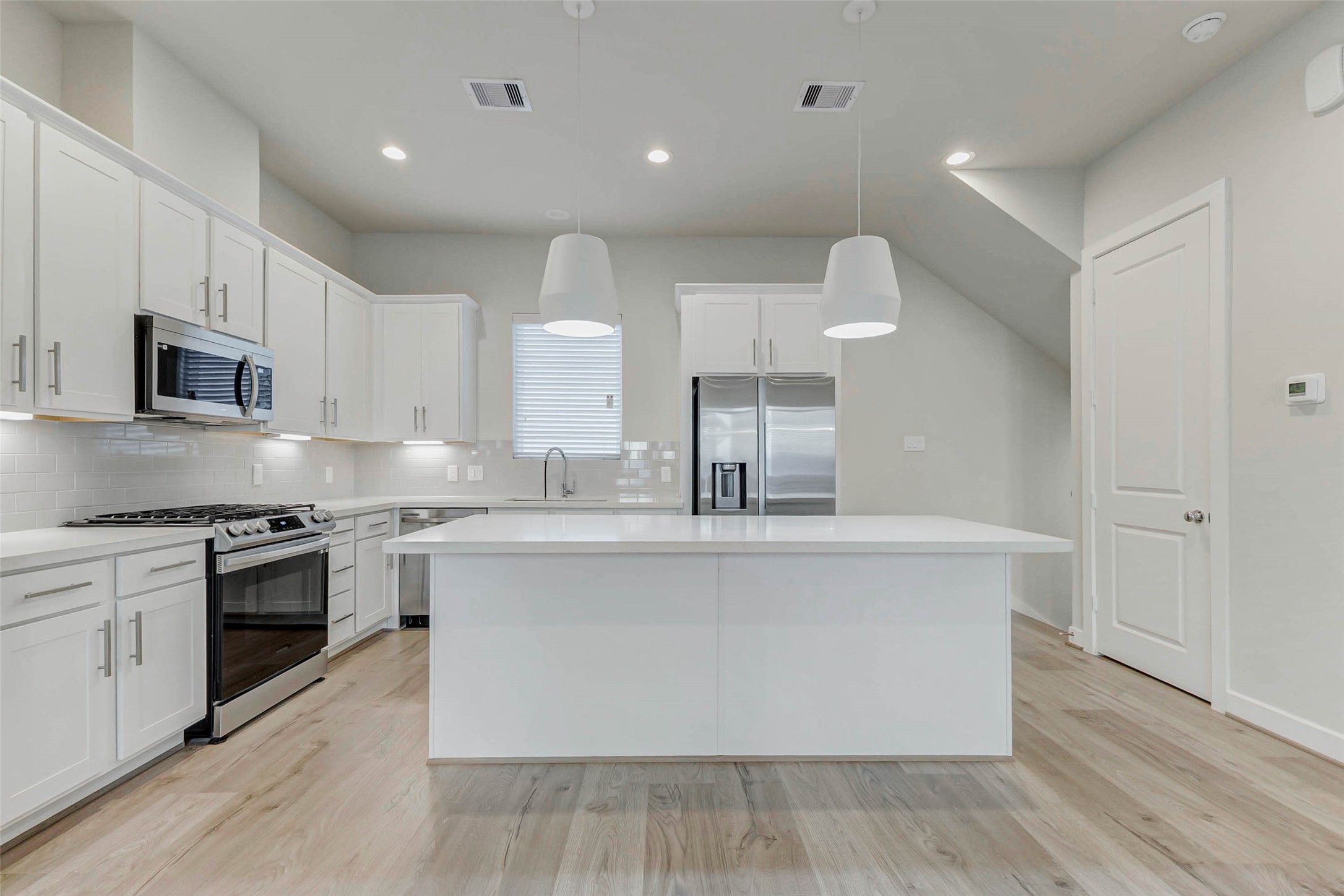 6313 Nelson Falls Lane Houston, TX 77008 - Photo 8 of 34 a large kitchen with stainless steel appliances a large counter top a stove a sink and a refrigerator