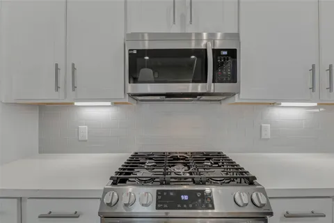 a stove top oven sitting inside of a kitchen