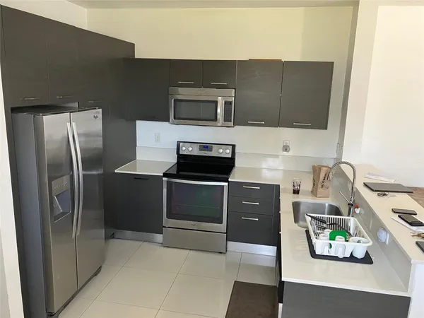 a kitchen with stainless steel appliances a microwave a sink and cabinets