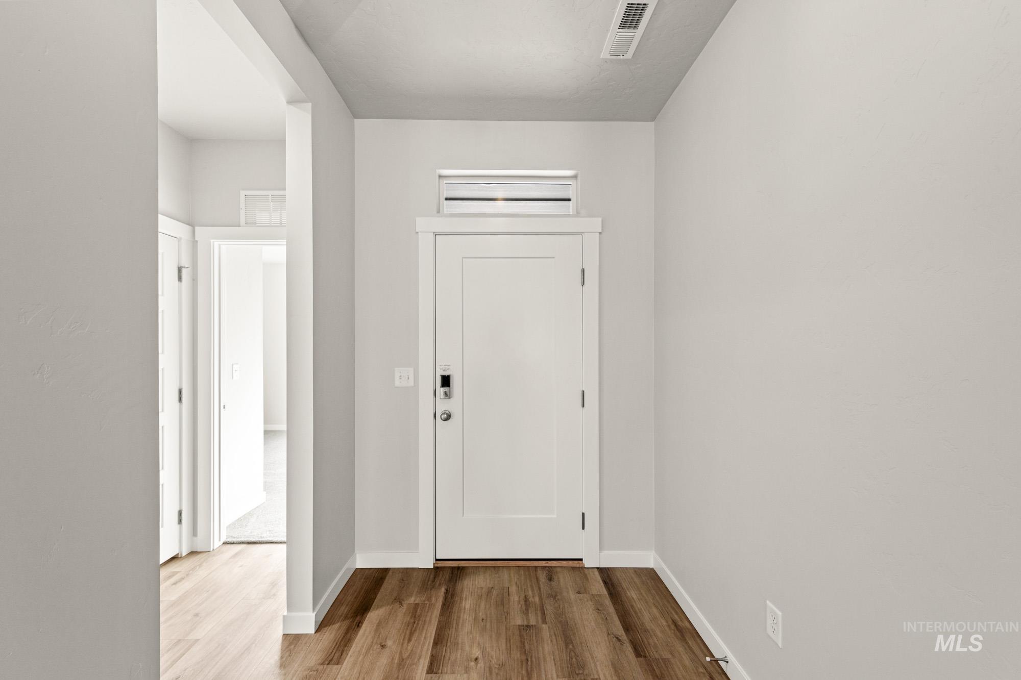 12865 Decatur Street Nampa, ID 83651 - Photo 2 of 20 Entryway featuring wood-finish flooring, a white paneled door with a transom window, and light-toned walls
