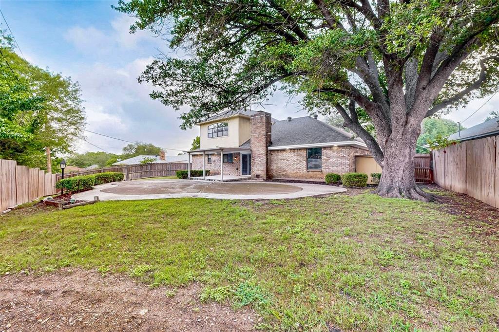 3965 Singleleaf Lane Fort Worth, TX 76133 - Photo 34 of 39 Expansive backyard featuring a large tree, a brick and stucco exterior, a covered patio, and a privacy fence