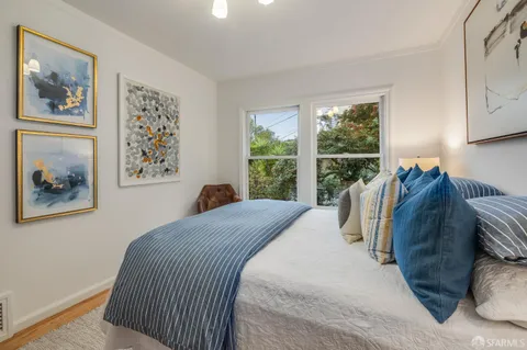 a bed sitting in a bedroom next to a window