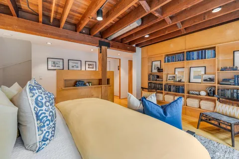 a spacious bedroom with a bed and glass table